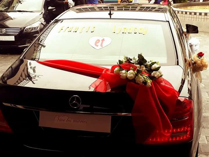 Voiture des mariés décorée — nœud rouge et roses blanches